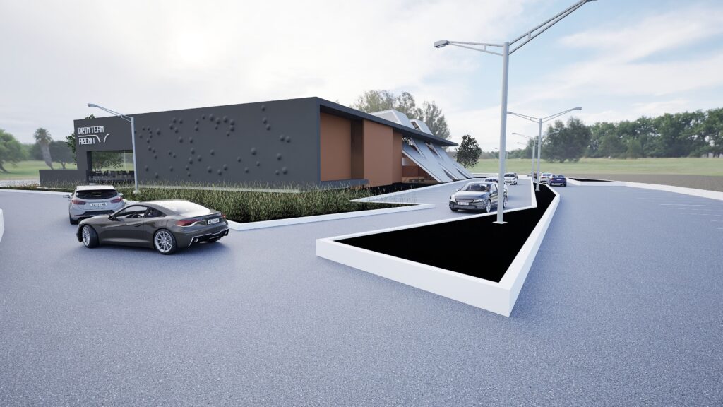 Modern basketball academy exterior with sleek black and beige building, landscaped greenery, parking area, and cars under a cloudy sky, showcasing contemporary architectural design and a welcoming sports facility. By Modify Architects