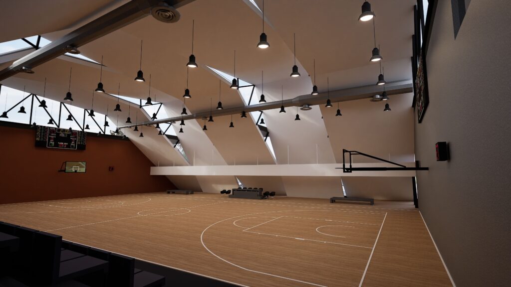 Interior view of the Drimalas Basketball Academy gymnasium, showcasing a spacious wooden basketball court with markings, a raised viewing platform with benches, a digital scoreboard, and a modern lighting system suspended from the arched ceiling, creating a bright and inviting atmosphere for training and games. By Modify Architects